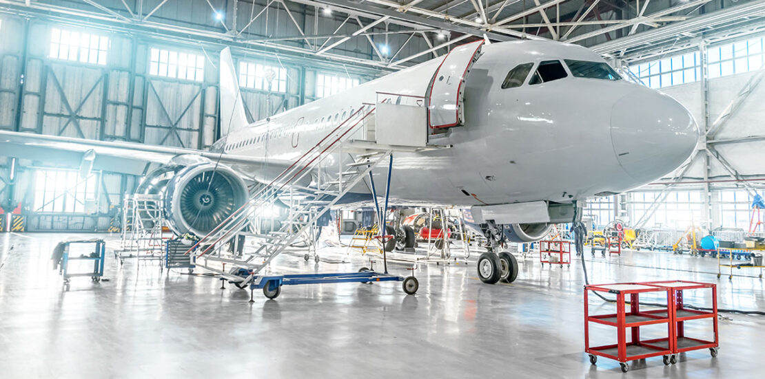 Aircraft under maintenance, checking mechanical systems for flight operations. Plane in the hangar