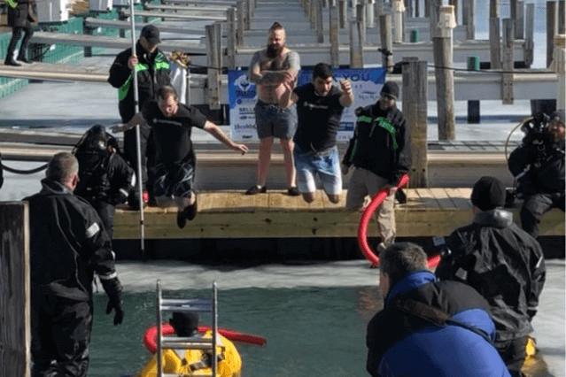 Momentum team members jumping into a frozen lake for the Polar Plunge event raising funds for Special Olympics Michigan