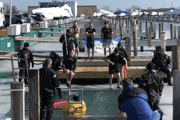 Momentum team members jumping into a frozen lake for the Polar Plunge event raising funds for Special Olympics Michigan