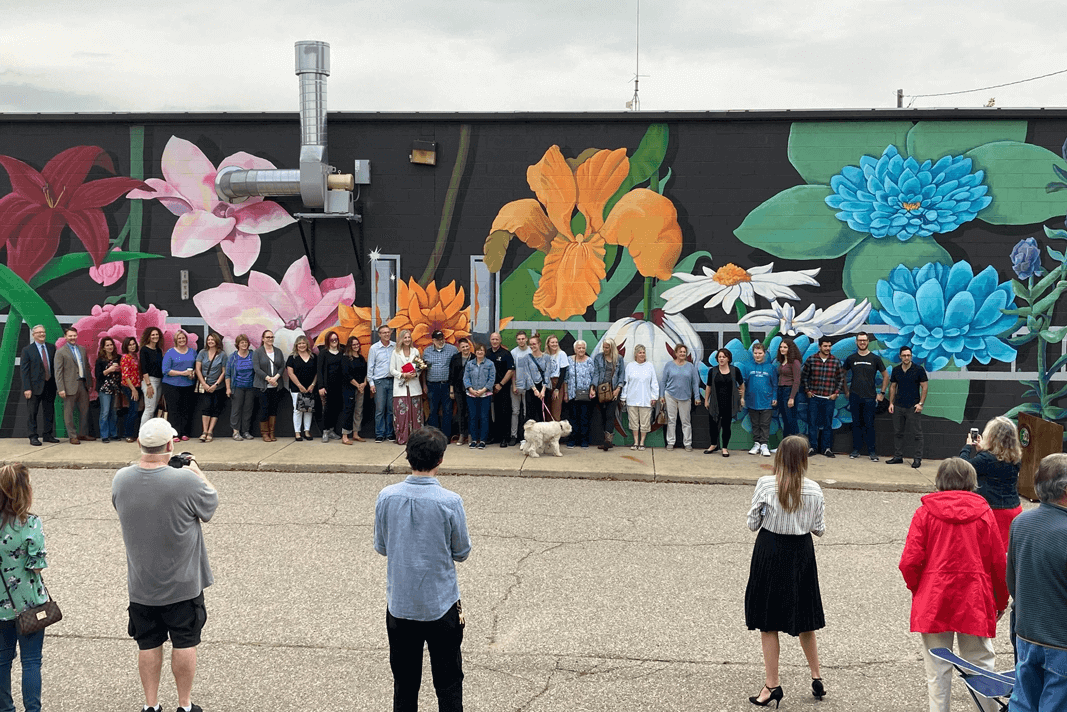 Utica residents and Momentum team posing for photo in front of the Utica Fire Station mural