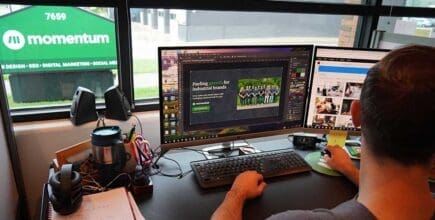 Male developer working on an industrial website design seated at a computer desk