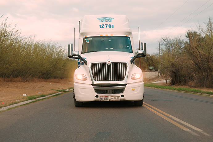 Photo of the front of a TSI truck driving down a road
