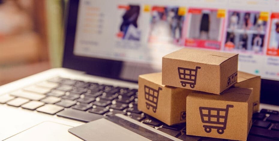 Shopping online. Cardboard box with a shopping cart logo in a trolley on a laptop keyboard payment by credit card and offers home delivery.