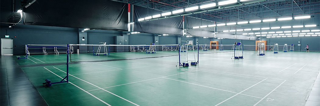 Big empty gymnasium with courts for playing tennis and badminton in health club