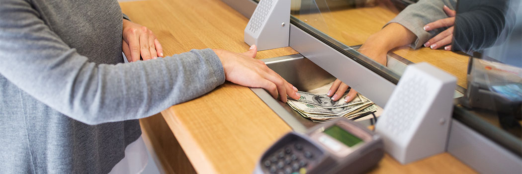 clerk giving cash money to customer at bank office