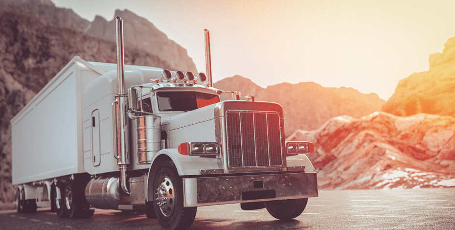 A white truck running on the street in the morning.