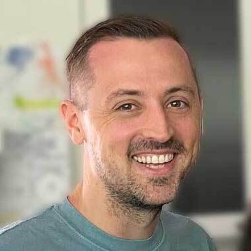 Smiling person in casual clothing with a blurred background