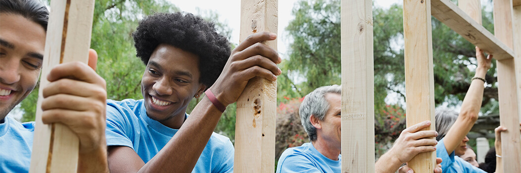 Group of volunteers holding wooden frame at park