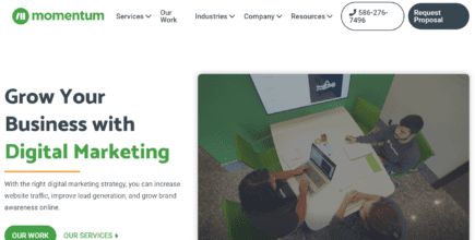 The hero section of Momentum's website. It features an image on the right of three employees sitting at a desk. To the left of that image is a short headline titled "Grow Your Business With Digital Marketing." Underneath that are two distinct calls-to-action links. The one on the left invites readers to view Momentum's portfolio and the link to the right of that invites readers to learn more about Momentum's services.