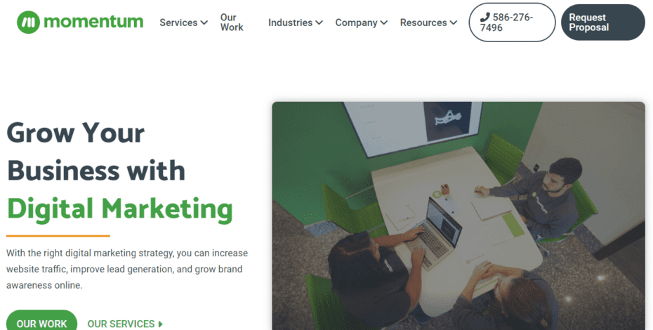 The hero section of Momentum's website. It features an image on the right of three employees sitting at a desk. To the left of that image is a short headline titled "Grow Your Business With Digital Marketing." Underneath that are two distinct calls-to-action links. The one on the left invites readers to view Momentum's portfolio and the link to the right of that invites readers to learn more about Momentum's services.