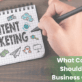A person has scribbled "Content Marketing" on an open notepad. Momentum's logo is in the top right. The text "What content should your business create?" is on the bottom right